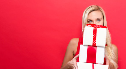 Happy young woman holding a stack of gift boxes
