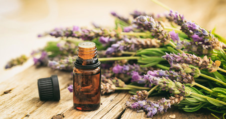 Fresh lavender and essential oil on wooden background