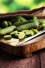 Fresh and sliced cucumbers. Sliced cucumbers on a cutting board.