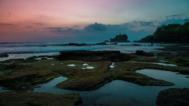 Sunset timelapse at the broken beach. In the distance one can see the temple of Tanah Lot on the island of Bali in Indonesia.