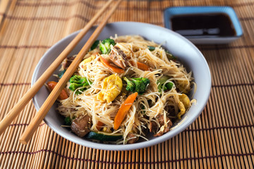 Asian rice noodles wok with chicken and vegetables