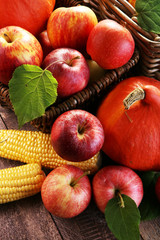Thanksgiving - pumpkin, apples, and maize on wooden background