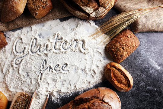 gluten free breads, glutenfree word written and bread rolls on grey background