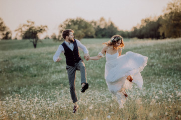 Beautiful bride and groom at sunset in green nature.