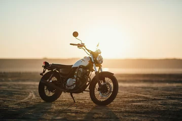  old custom beautiful cafe racer motorcycle in the desert at sunset or sunrise 