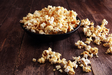 Salt popcorn or sweet popcorn in bowl on the wooden table