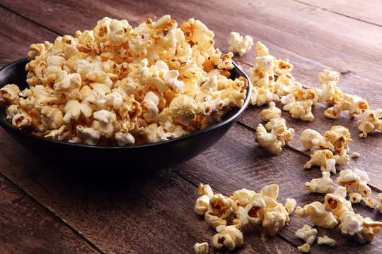 Salt popcorn or sweet popcorn in bowl on the wooden table