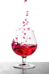 Hearts fall in a glass of wine