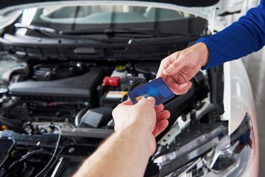 Hands Of Car Mechanic With Wrench In Garage, Payment By Credit Card