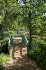 Footbridge to English countryside lake in Summer gardens