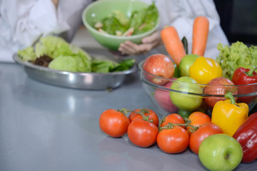Colorful vegetables and fruits on little chef background in the kitchen