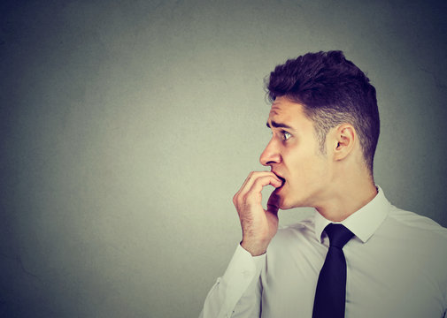 Preoccupied Anxious Man Biting His Fingernails Looking To The Side