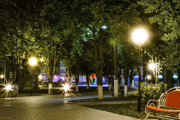 An empty city steet at night. Walkway illuminated with the lanterns. The town of Pokrov, Ukraine