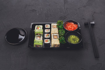 Set of sushi maki and rolls closeup in delivery box