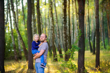 Fototapeta premium Dad is walking with his beloved daughter in a beautiful evening park