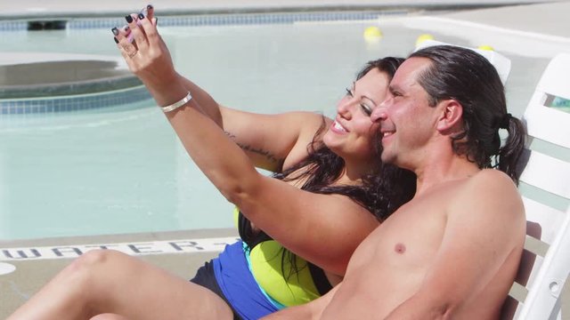 Man and woman take a selfie by the pool