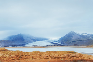 Gentle slopes of snow-capped mountains and glaciers. Wonderful Iceland in the spring.