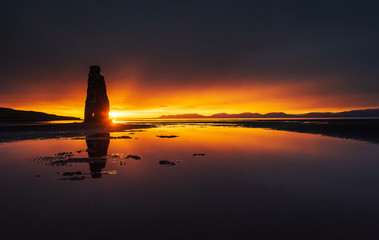 Is a spectacular rock in the sea on the Northern coast of Iceland. Legends say it is a petrified troll. On this photo Hvitserkur reflects in the sea water after the midnight sunset.