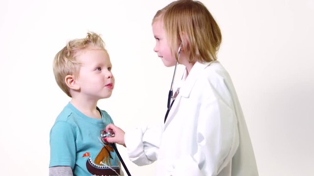 Little doctor girl checking boys heart