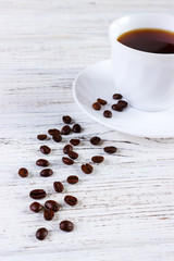 Warm cup of coffee with a coffee beans on background