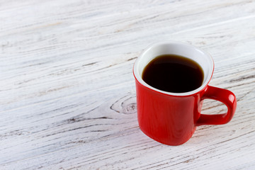Red Coffee cup on wooden table. View from top