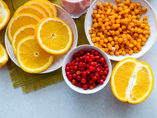 A bowl of sea-buckthorn and cranberries, oranges on the kitchen table