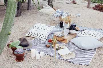 Fotobehang Eetkamer Top view on still life outdoor picnic blanket setup for romantic day or night out for hipster stylish couple, wedding, proposal happening with candles and chic snacks  © BublikHaus