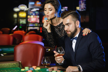 Beautiful and rich couple playing roulette in the casino