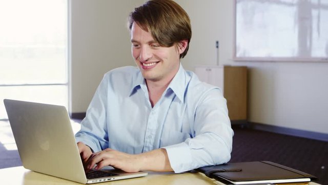 Smiling man using laptop