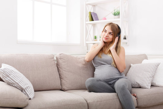 Pregnant woman listening to music in headphones