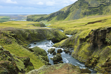 Naklejka na ściany i meble River flowing into the waterfall Skogarfoss in Iceland