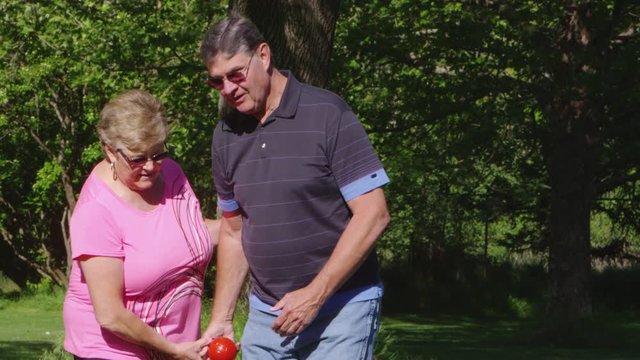 Elderly couple in the park playing bocce