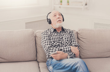 Senior man listening to music with headphones