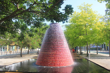 Volcano Fountain at the Nations Park, known as Parque das Nacoes. Famous area, north east part of Lisbon city, Portugal. Popular outdoor place for locals and tourists for a walk on sunny summer day.  - obrazy, fototapety, plakaty
