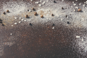 Fototapeta na wymiar Scattered salt and pepper on dark background