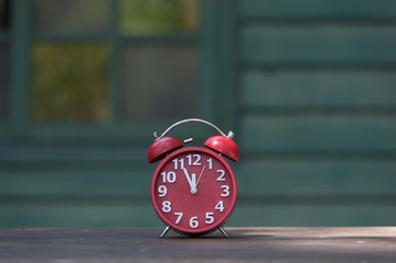 Retro alarm clock with five minutes to twelve o'clock.