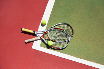 A tennis racket and new tennis ball on a freshly painted tennis court