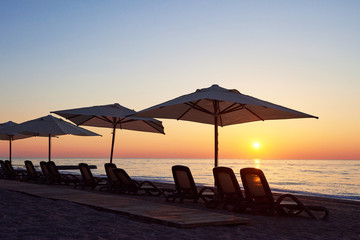Scenic view of sandy beach on the beach with sun beds and umbrellas open against the sea and...