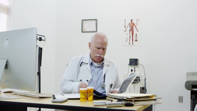 Elderly doctor checking x-rays