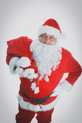 Real Santa Claus carrying big bag full of gifts, isolated on white background