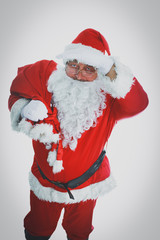 Real Santa Claus carrying big bag full of gifts, isolated on white background