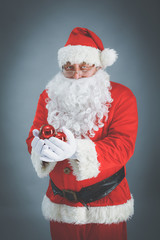 Real Santa Claus carrying big bag full of gifts, isolated on white background