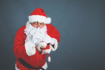 Real Santa Claus carrying big bag full of gifts, isolated on white background
