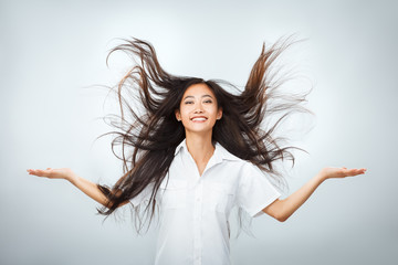 Happy young Asian woman with beautiful flying long hair