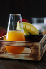 Glass with fresh mango juice in wooden box