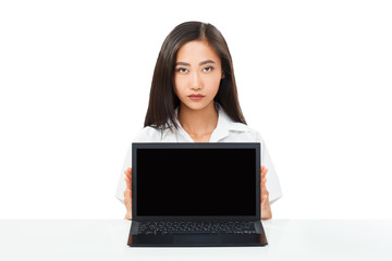 Serious Asian woman sitting with laptop with black blank screen