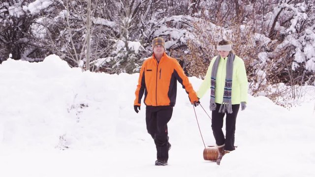 Slow motion couple pulling a bobsled