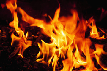 Red hot background of fire as a symbol of hell and eternal torment. Selective focus.