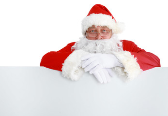 Fototapeta na wymiar Happy Santa Claus looking out from behind the blank sign isolated on white background