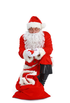 Real Santa Claus carrying big bag full of gifts, isolated on white background